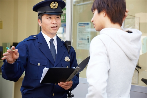 警察官と話す男性